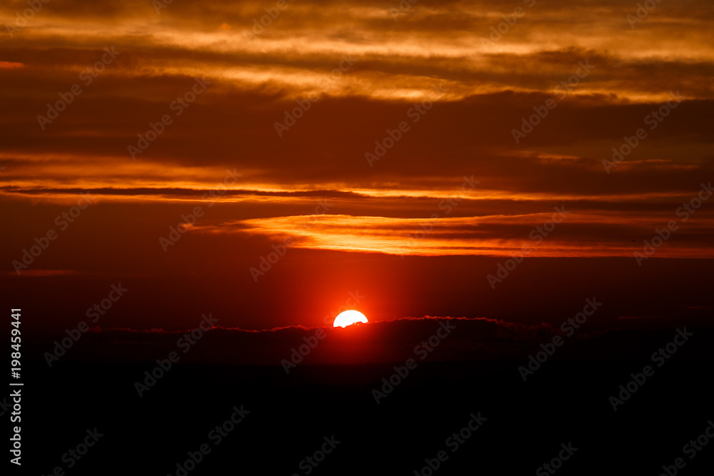 amazing sun at dusk clouds. sunset image. beautiful red cloudy sunset  in orange sky, dramatic view. fascinating wallpaper. beautiful nature moments, breathtaking scenery. pure beauty