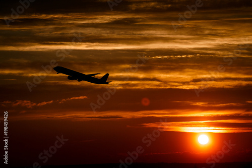Airplane at sunset sky in the air with space for text. Silhouette of a big passenger aircraft in sun light. transportation concept. plane flying in the dramatic sky. amazing atmospheric image