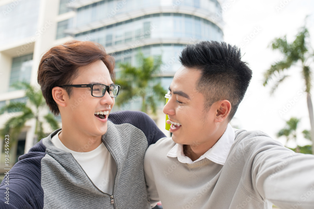 Fototapeta premium Best friends. Two guys hugging and walking in the city.