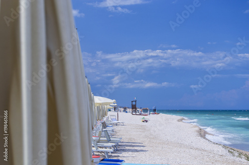 beach of marotta in the italian region of marche during summer with parasols and clouds