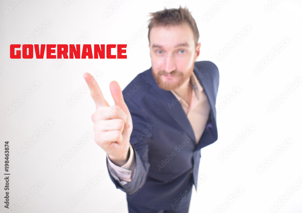 A businessman shows an inscription:GOVERNANCE A businessman shows an inscription:GOVERNANCE