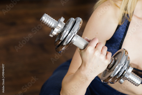 Fit woman lifting dumbbells weights