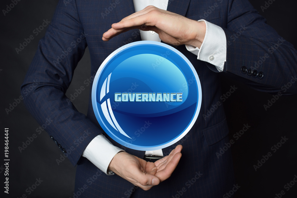 In the hands of a businessman, a neon circle with the inscription:GOVERNANCE In the hands of a businessman, a neon circle with the inscription:GOVERNANCE
