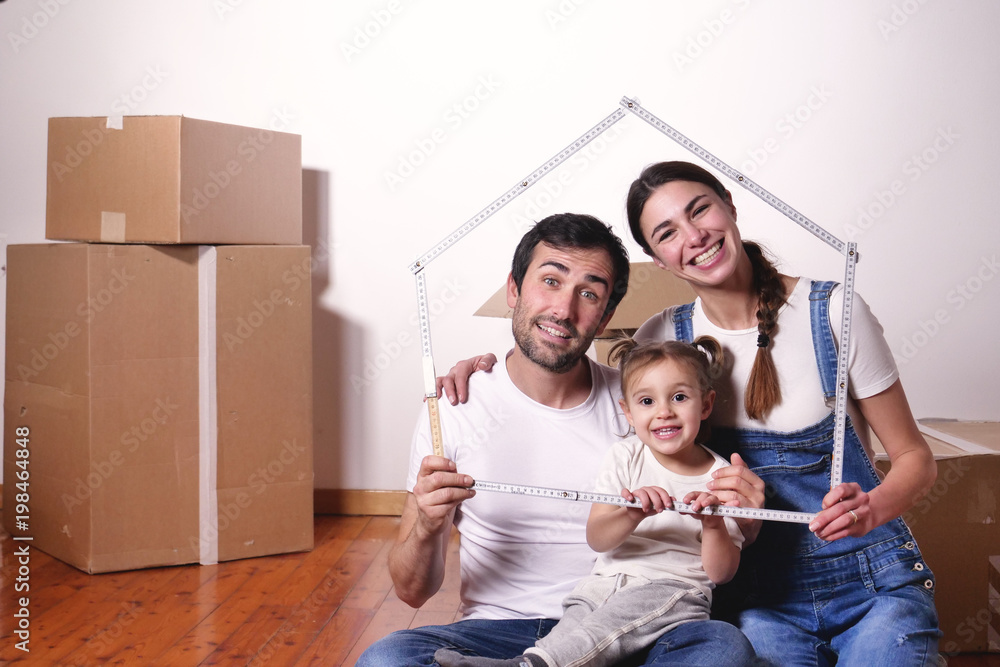 Portrait of a beautiful happy and smiling family just arrived in the new house to start a new journey together. Concept of: love, family, home. Portrait of a beautiful happy and smiling family just arrived in the new house to start a new journey together. Concept of: love, family, home.