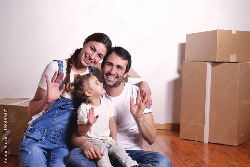 Portrait of a beautiful happy and smiling family just arrived in the new house to start a new journey together. Concept of: love, family, home. Portrait of a beautiful happy and smiling family just arrived in the new house to start a new journey together. Concept of: love, family, home.