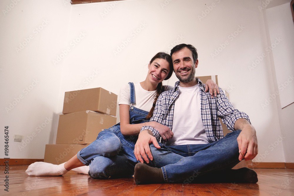 Portrait of a beautiful smiling couple of lovers just arrived in the new house to start a new journey together. Concept of: love, family, home. Portrait of a beautiful smiling couple of lovers just arrived in the new house to start a new journey together. Concept of: love, family, home.