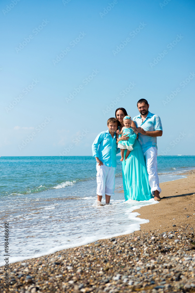 Family of four having fun on tropical beach