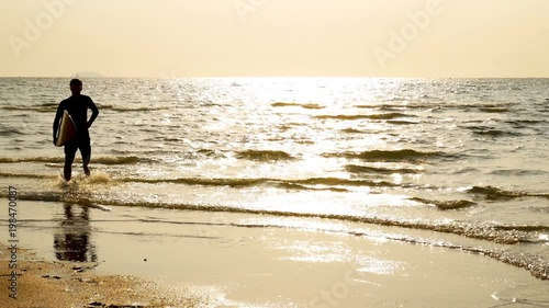 4K. silhouette of young happy surf man running with long surf boards at sunset on tropical beach. surfer on the beach in sea shore at sunset time with beautiful light. surfing for water sport activity