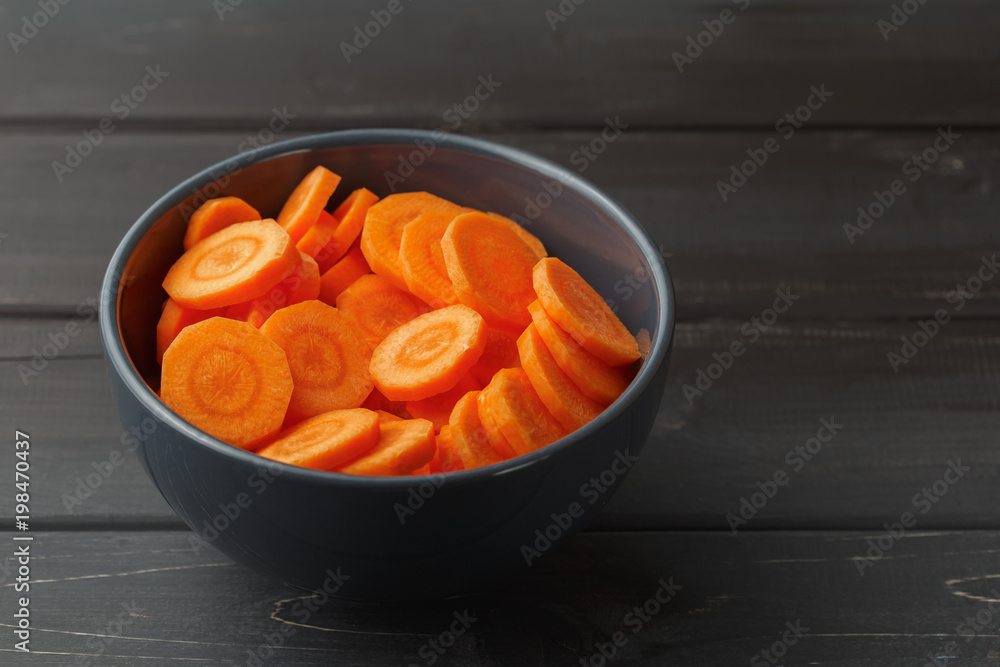 Sliced carrots in a bowl on black background Sliced carrots in a bowl on black background