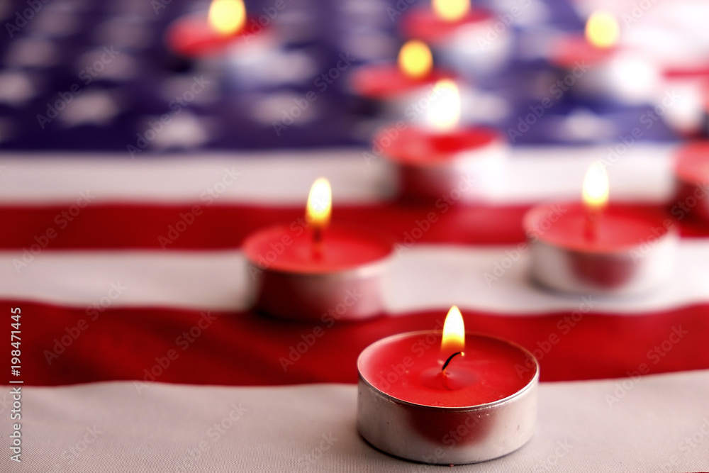 Mourning candles burning on USA American national flag background. Memorial weekend, patriot veterans day, 9/11 National Day of Service & Remembrance. Moment of silence concept. Close up, copy space. Mourning candles burning on USA American national flag background. Memorial weekend, patriot veterans day, 9/11 National Day of Service & Remembrance. Moment of silence concept. Close up, copy space.