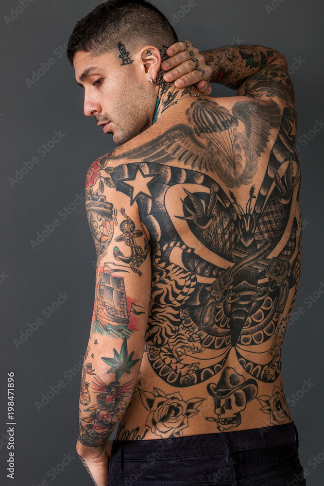 Handsome man back portrait with tattoos all over his body Stock Photo