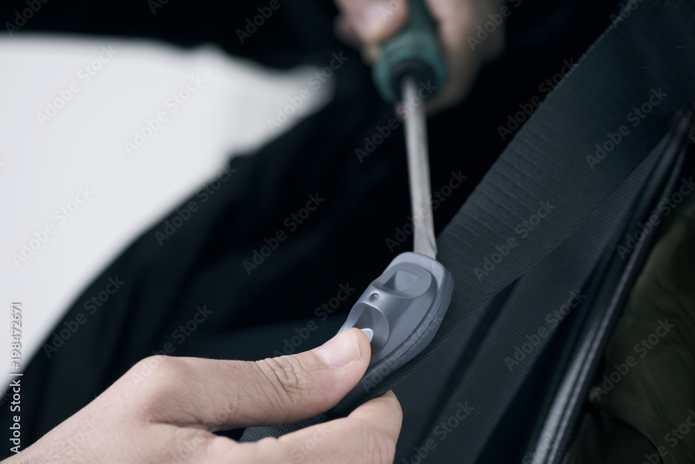 man removing a security tag with a screwdriver