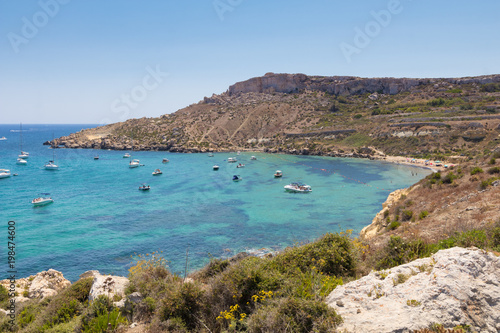 Beautiful azure blue water of Selmun beach in the summer time, in Maltese Imgiebah Bay, Il-Mellieha, Malta, June 2017