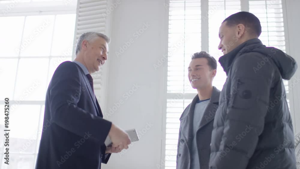 Young male couple get handed the keys to their new property Young male couple get handed the keys to their new property
