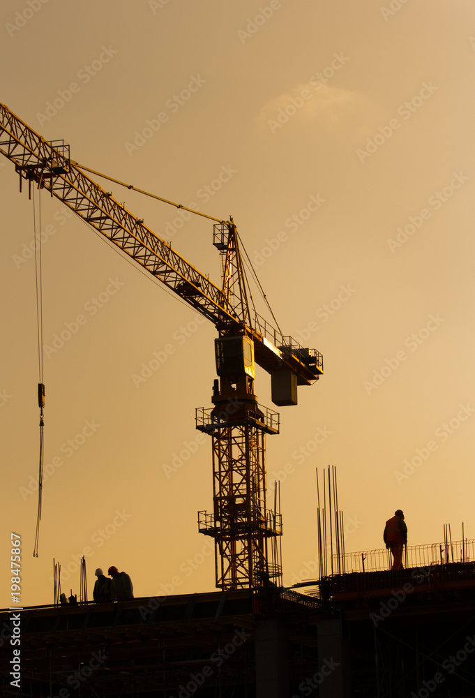 Construction workers on building site at sunset