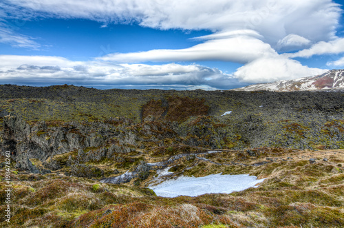 A dramatic view of the lava fields in iceland with the perfect compliment of a fluffy cloudscape