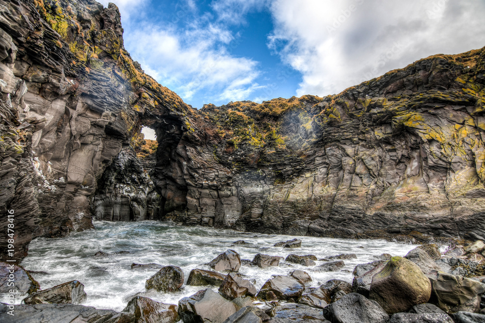 A lovely yet violent cave gushing water on the coast of Iceland