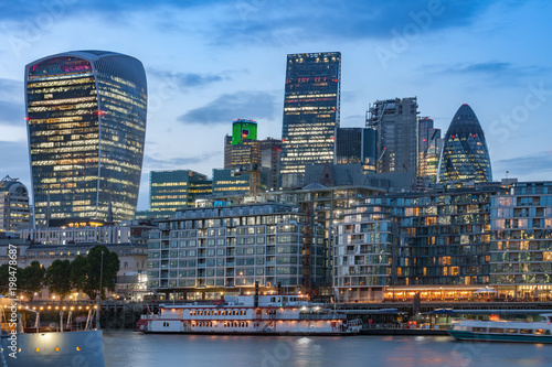 Thames embankment and london skyscrapers in City of London after sunset photo