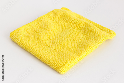 Yellow folded microfiber cloth on white background