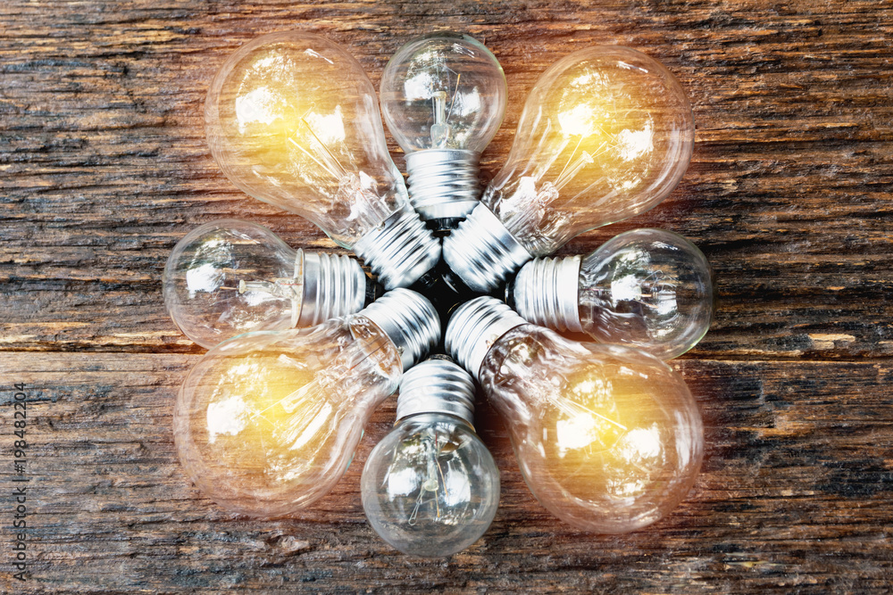 Light bulbs with glowing on wooden table background. Idea, creativity and saving energy with light bulbs concept. Light bulbs with glowing on wooden table background. Idea, creativity and saving energy with light bulbs concept.