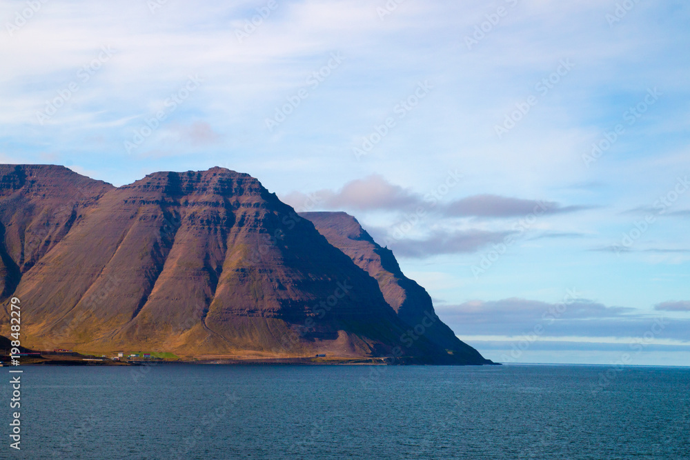 High West Fjords over deep blue ocean coast near the city of Ísafjörður in Iceland