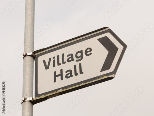 white and black village hall sign post direction street