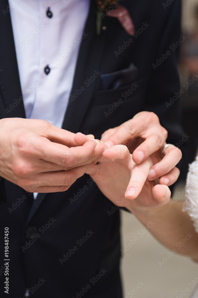 Fototapeta premium Groom Putting Ring on Bride's Finger