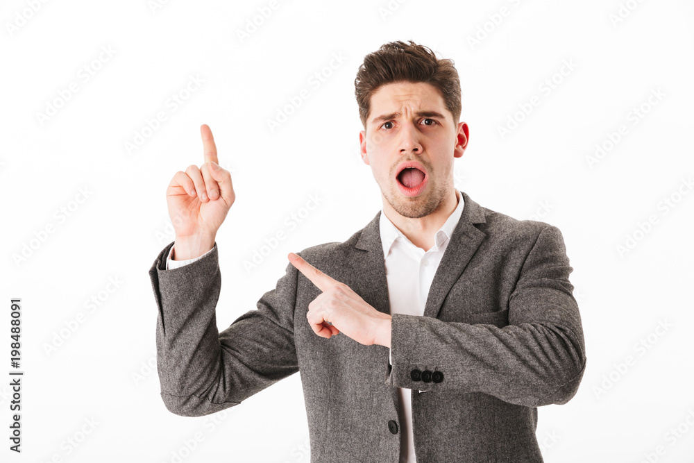 Shocked business man in jacket pointing up and away Shocked business man in jacket pointing up and away