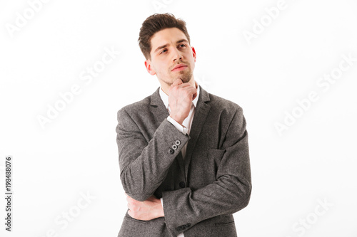 Pensive business man in jacket holding chin and looking away © Drobot Dean