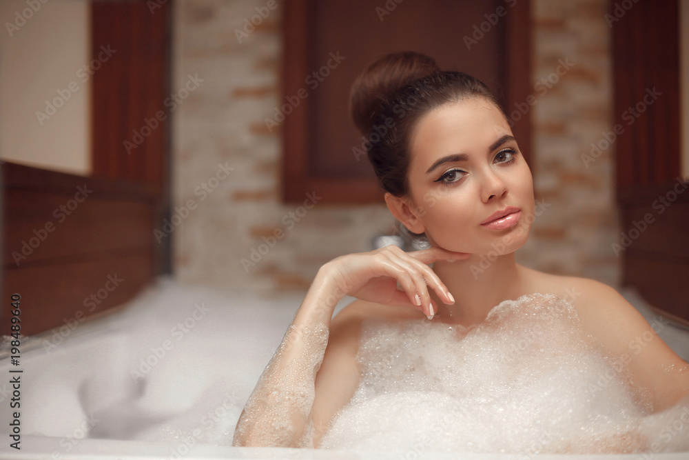 Skincare. Wellness. Young woman relaxing in jacuzzi bath spa, brunette enjoying foam bath in bathroom. Beauty skin care treatment. Beautiful model relax at home. Skincare. Wellness. Young woman relaxing in jacuzzi bath spa, brunette enjoying foam bath in bathroom. Beauty skin care treatment. Beautiful model relax at home.