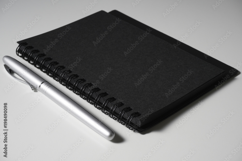 Low key lighting black book and silver pen Low key lighting black book and silver pen