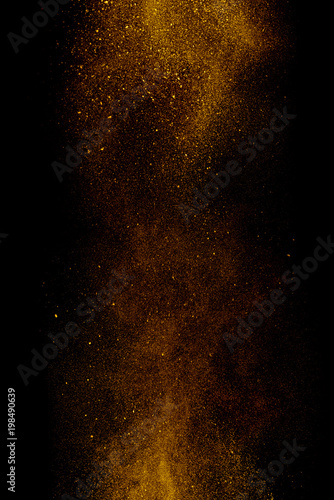 Gold dust on a black background. Fine particles in motion.