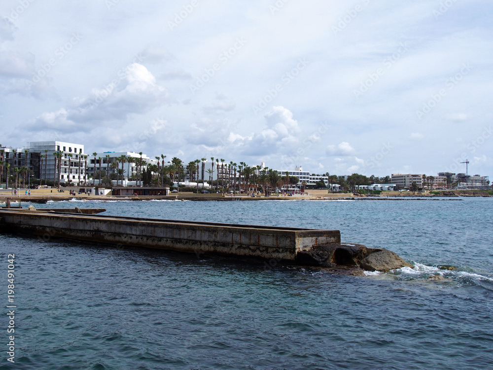 view of the the seafront and harbour in paphos cyprus with hotel buildings and promenade