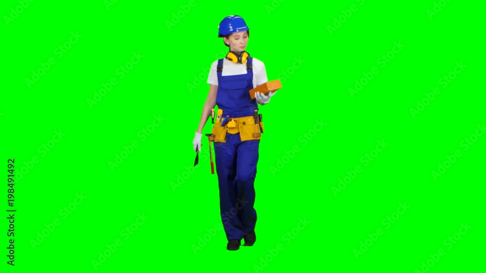 Girl builder carries a brick for construction. Green screen Girl builder carries a brick for construction. Green screen
