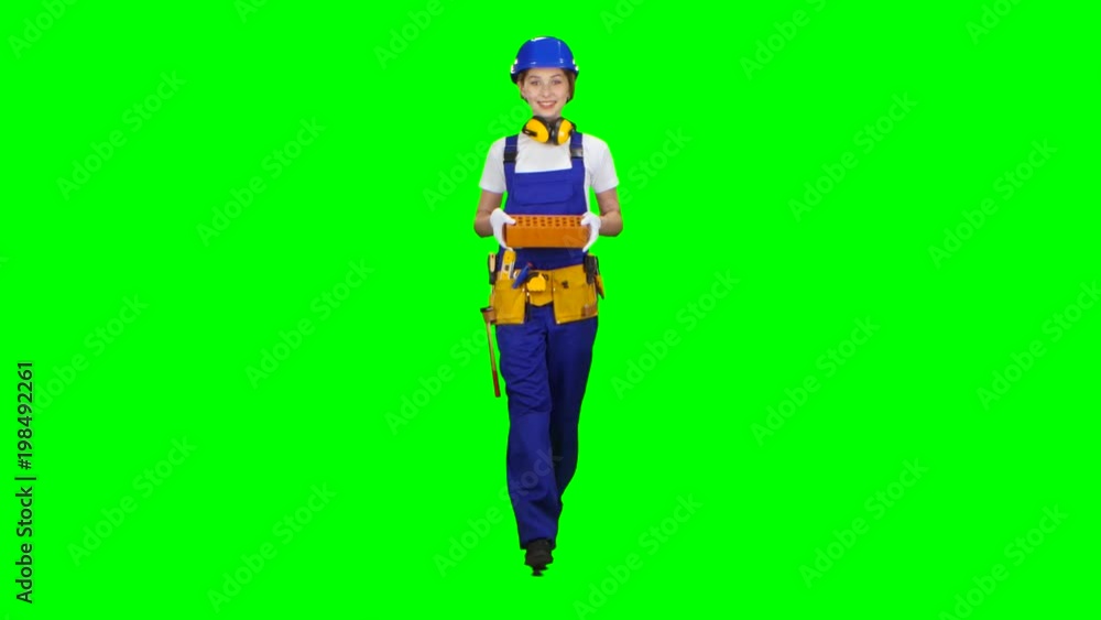 Builder carries a brick for construction. Green screen Builder carries a brick for construction. Green screen