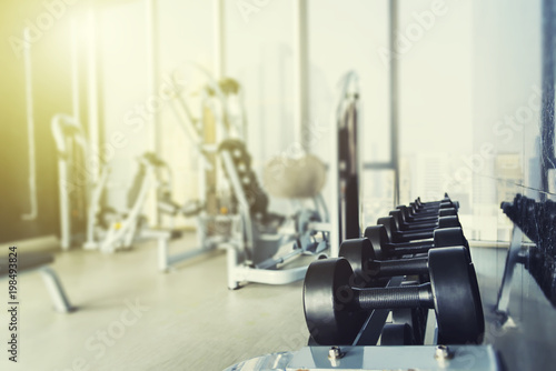 Fitness and healthy background concept. Dumbbells with blurred gym or sport club background at sunset. Picture for add text message. Backdrop for design art work.