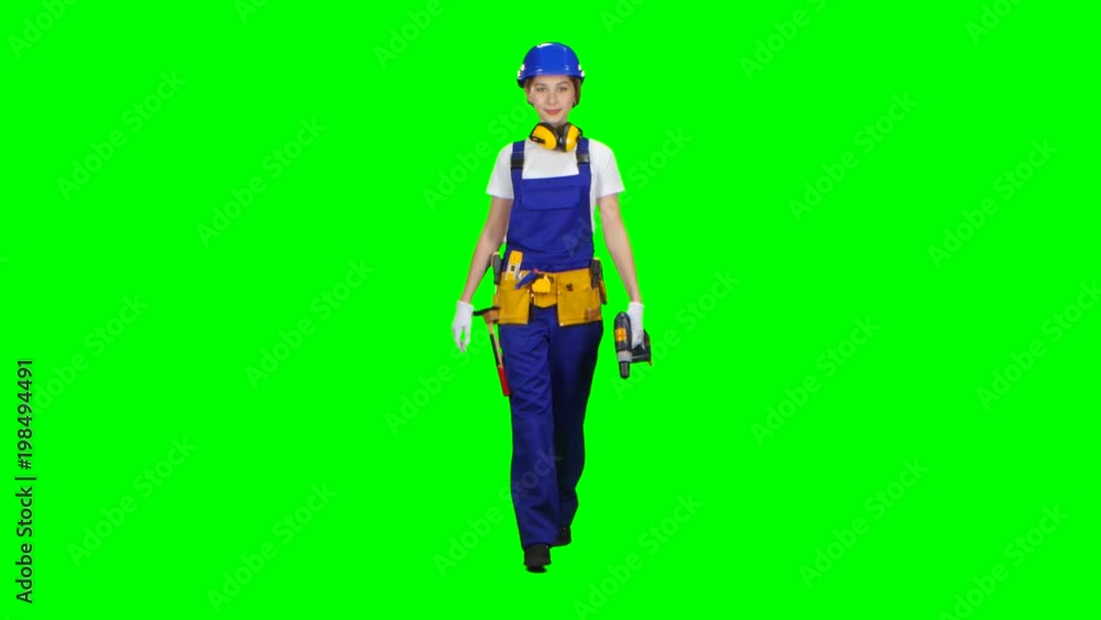 Brigadier girl comes with a drill in her hands. Green screen. Side view Brigadier girl comes with a drill in her hands. Green screen. Side view