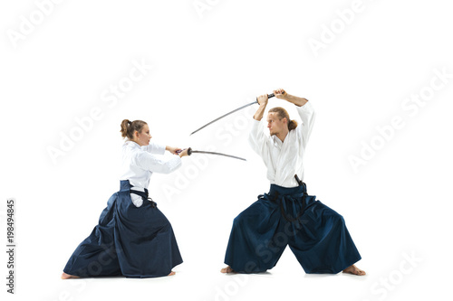 Man and woman fighting and training aikido on white studio background