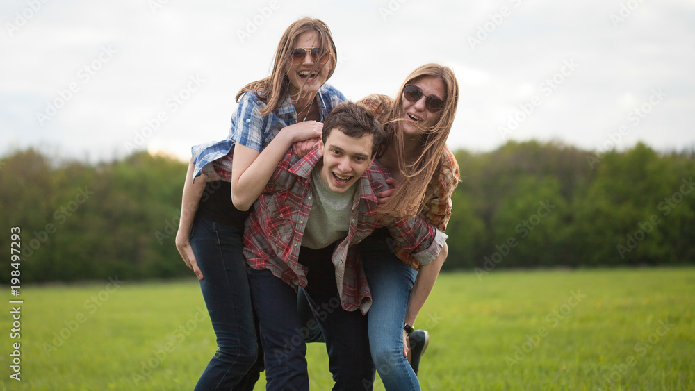 Fun outdoors. Young man and two young woman making fun Fun outdoors. Young man and two young woman making fun