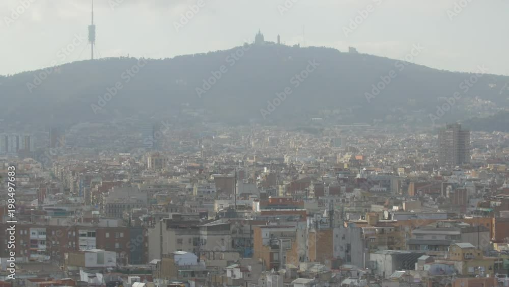 Barcelona cityscape with buildings and a hill