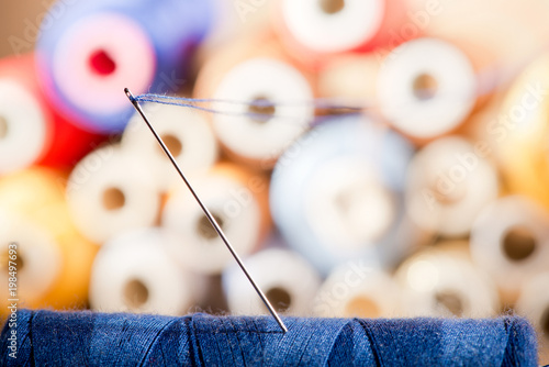 Detail of a needle with thread in the workroom