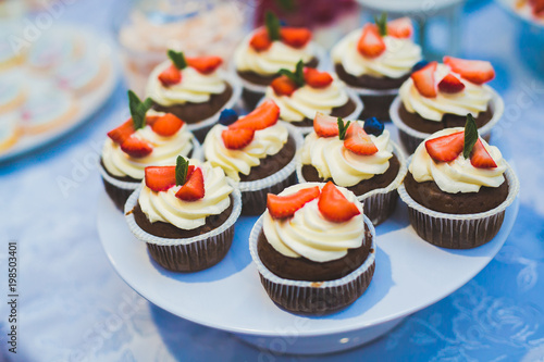 Delicious sweets on wedding candy buffet with desserts, cupcakes