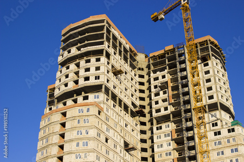 Modern multi-storey building in the city on the shore on blue sky background photo