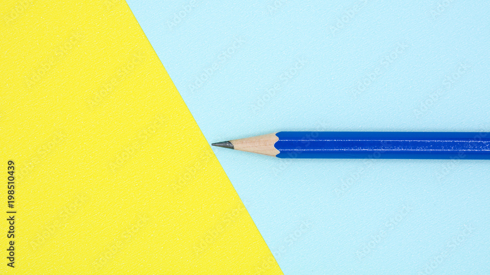 blue pencil on blue and yellow paper - background blue pencil on blue and yellow paper - background
