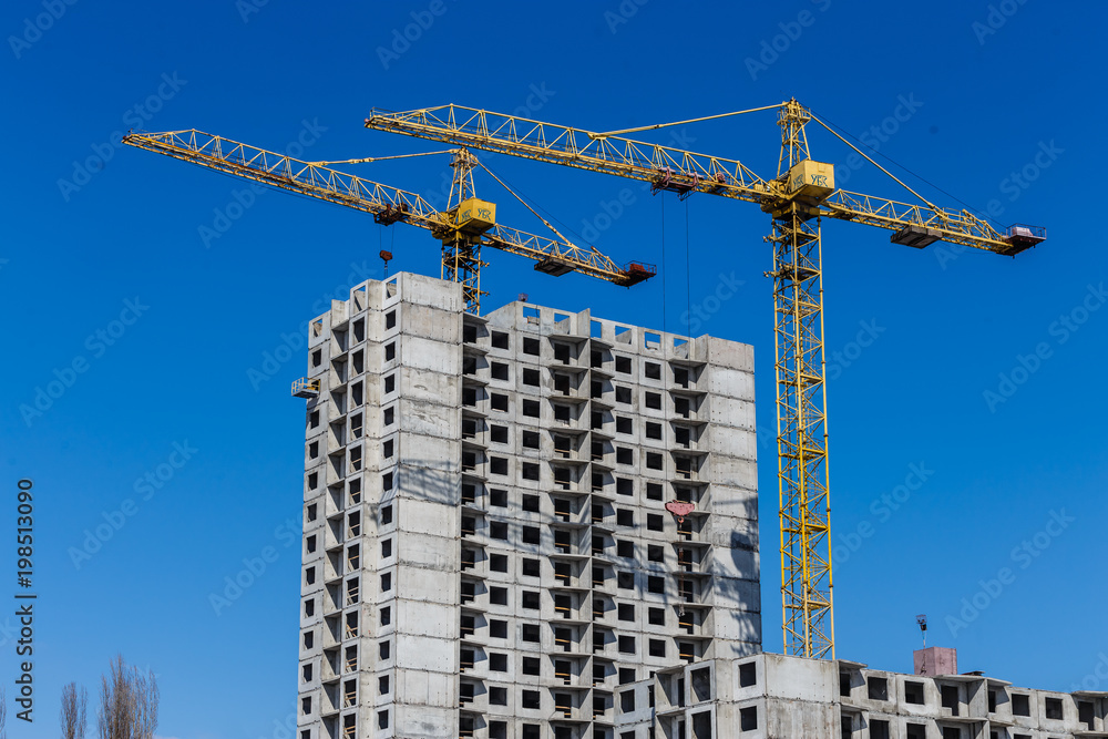 Lots of tower construction site with cranes and building with blue sky background
