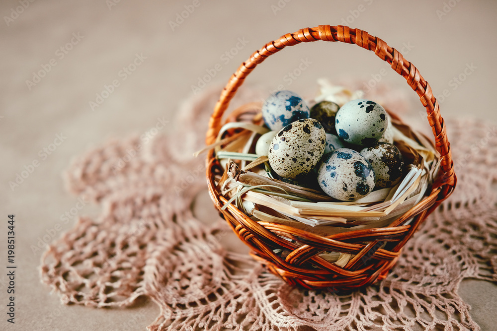 Obraz premium Easter holiday decoration. Quail eggs wrapped in hay in woven basket