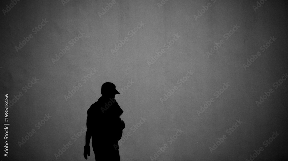 silhouette of a man front the concrete wall - heavy noise and grains background