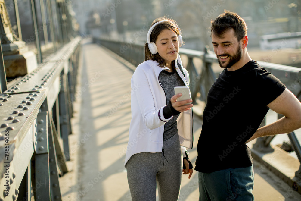 Athletic couple is having a rest after jogging in the city