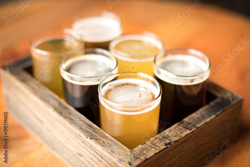 Φωτογραφία Close up on a flight of craft beers in a wood sampling tray