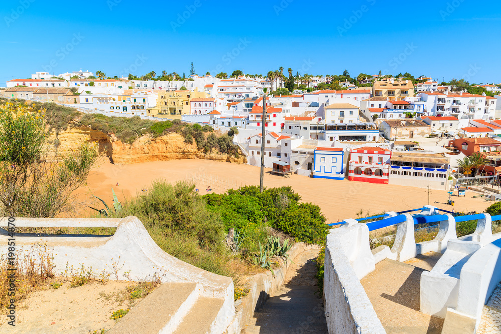 Coastal path to beach in Carvoeiro village with colorful houses, Algarve region, Portugal